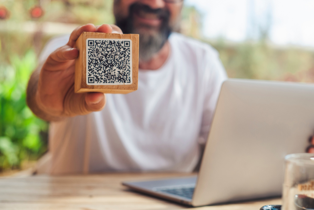 Man inbackgorund showing qr code menu at the cafe. Digital onlin